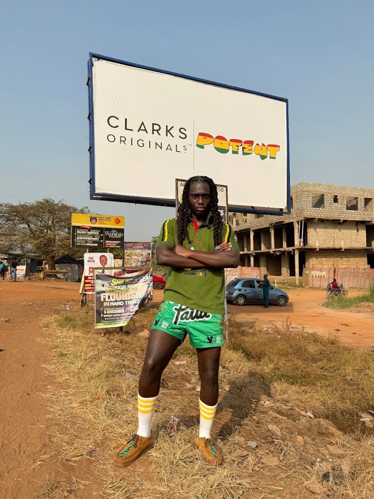 Creative Director Kwabena Asante infront of a billboard